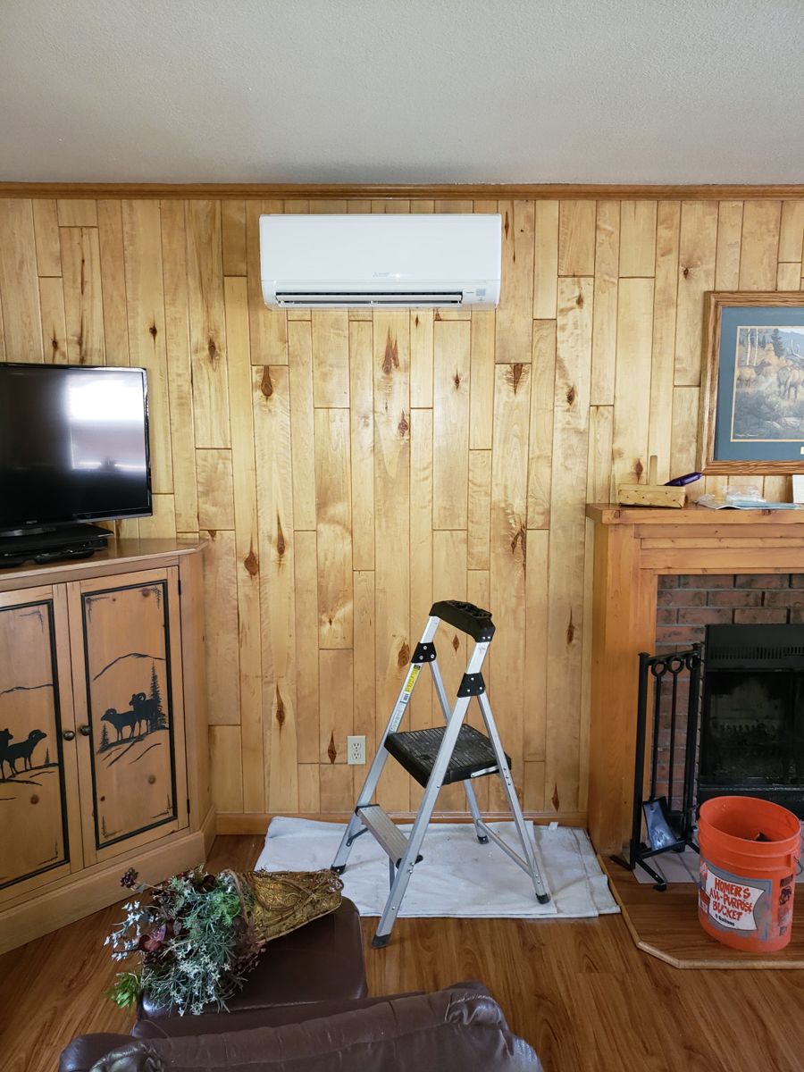 Wall-mounted ductless mini split installed on a knotty pine wall in a Colorado mountain home